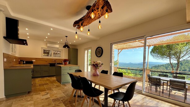 A modern kitchen with a dining area, large windows, and a view of the landscape. - Provençal Villa with Private Pool, Panoramic Views & Sleeps 10 (Fayence)