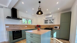 A modern kitchen with a central island, built-in oven, and a microwave. - Provençal Villa with Private Pool, Panoramic Views & Sleeps 10 (Fayence)