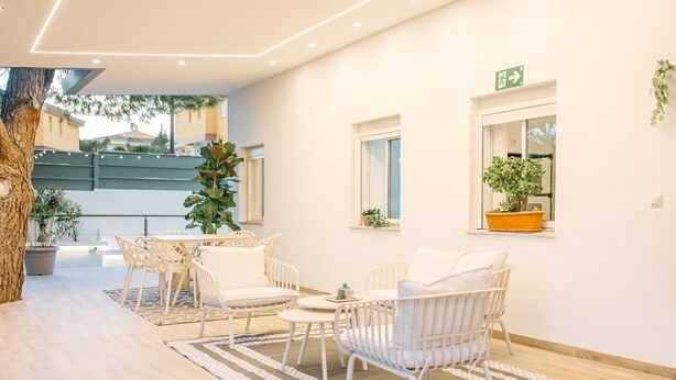 Un intérieur moderne avec un coin repas, des meubles blancs et des plantes en pot.