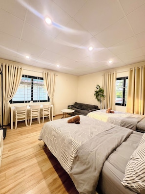Una habitació d'hotel amb un llit, una taula de treball, una cadira, un sofà i una finestra.