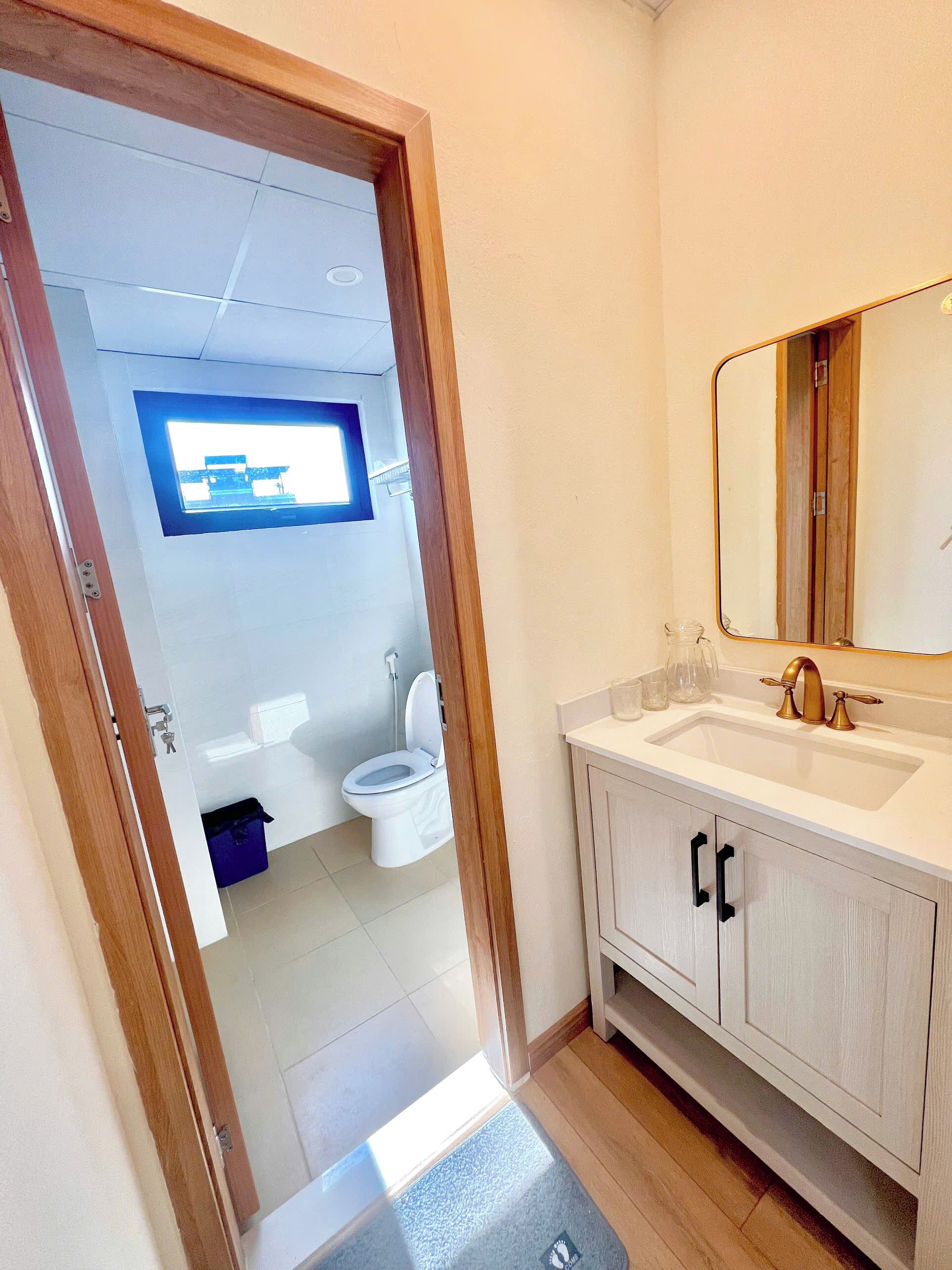 A bathroom with a toilet, sink, and mirror.