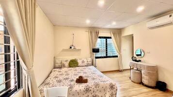 A bedroom with a bed, a bedside table, a chair, a mirror, and a window with curtains.