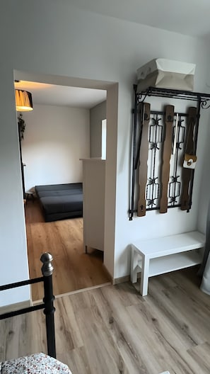 A room with a bed, a bench, a wall-mounted ski rack, and a small table.