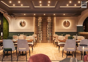 Un restaurante con una estantería central para vinos, varias mesas y sillas.