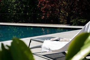 A poolside area with a lounge chair, a pool, and a fence. - Villa Maderni Peaceful Haven by MyHomeInComo (Como)