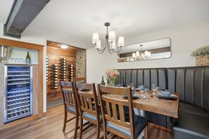 A dining area with a wooden table, chairs, a wine rack, and a wine cooler. - Vintage 2BR Carlton retreat with hot tub, EV charging, and game room. (Carlton)