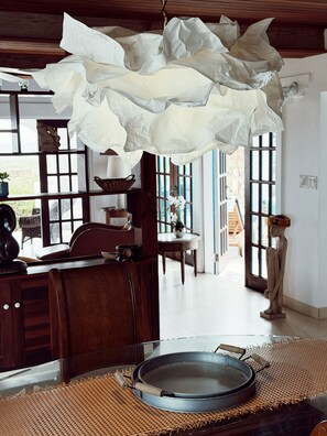 A room with a large window, wooden furniture, and a hanging light fixture. - Anguilla Spacious House Beautiful Views 3 Bedroom (East End)