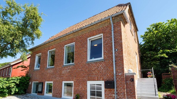 A red brick building with a tiled roof, multiple windows, and a gravel driveway. - 10 Person Holiday Home in Bovlingbjerg (Bøvlingbjerg)