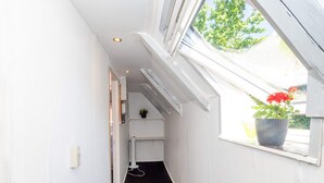 A narrow hallway with white walls, a black carpet, and a skylight with a potted plant. - 10 Person Holiday Home in Bovlingbjerg (Bøvlingbjerg)