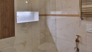 Un baño moderno con cabina de ducha de vidrio, bañera independiente y un inodoro.