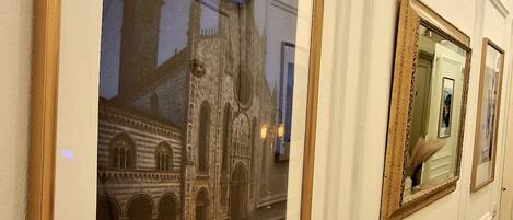 A corridor with framed artworks on the walls.