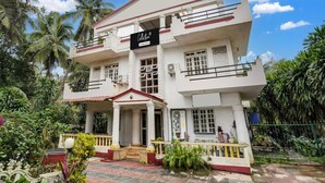 A two-story building with a sign reading 'Collection.' - Deluxe With Balcony Calangute Goa (Calangute)