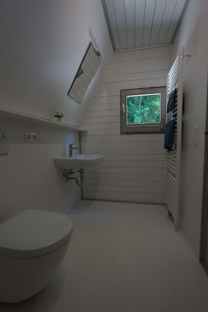 A compact bathroom with a toilet, sink, and window. - Vacation Home 1 (Kinding - Kratzmühle)