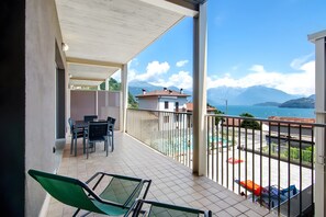 A balcony with a view of mountains and a swimming pool.