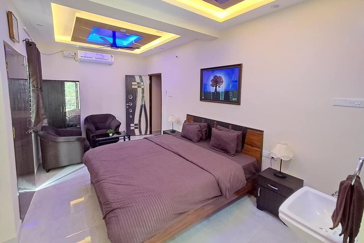 A modern bedroom with a bed, bedside tables, a chair, and a ceiling fan.