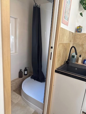A bathroom with a shower, a sink, and a toilet.