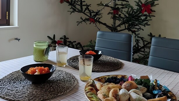 Ein Esstisch mit einem grünen Glas, einer schwarzen Schüssel und einem Tablett Gebäck.