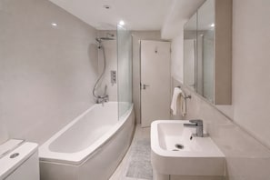 Ein modernes Badezimmer mit einer Glasdusche, einer freistehenden Badewanne und einem Standwaschbecken.