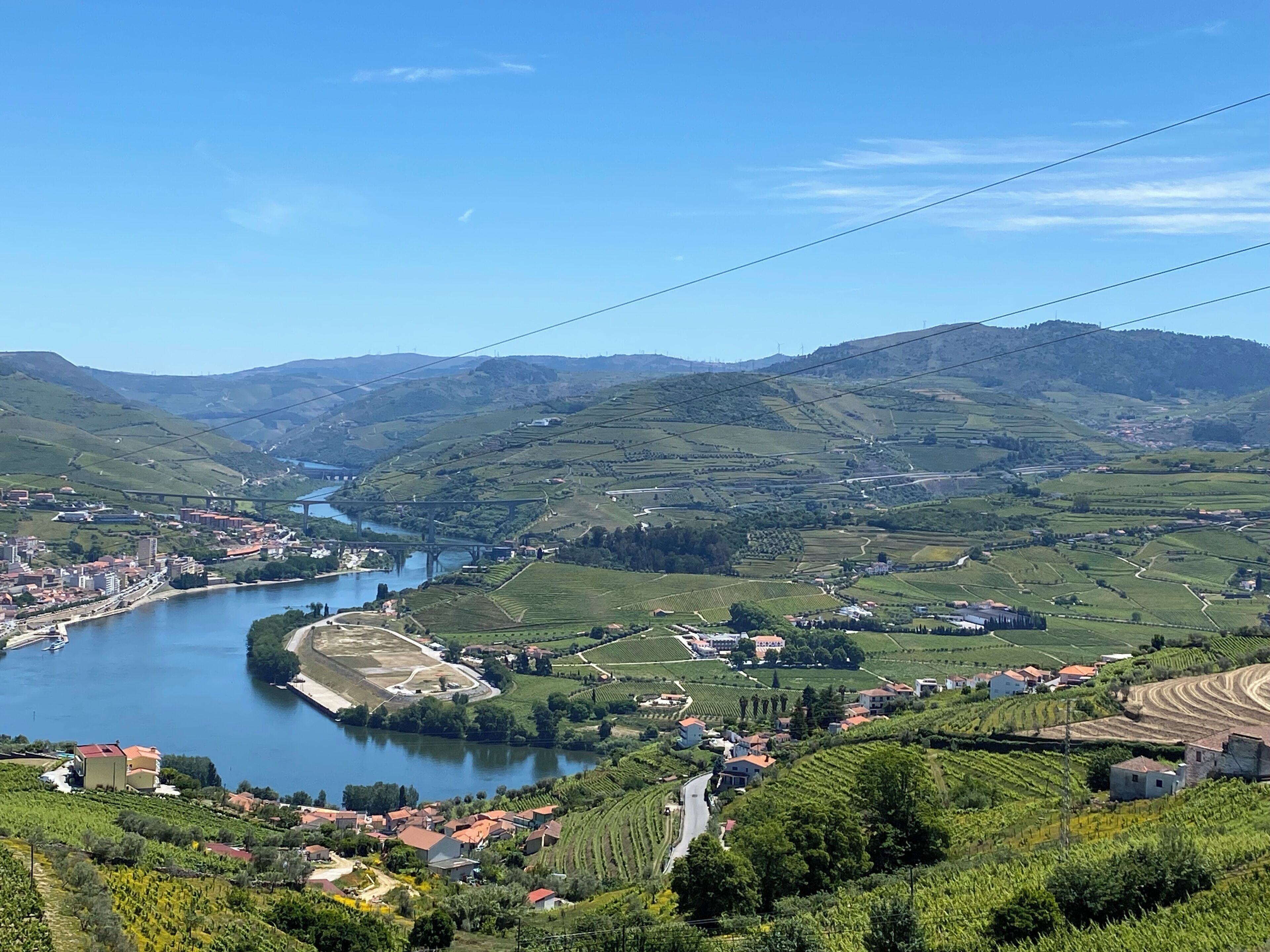A river winding through a valley with vineyards and buildings.