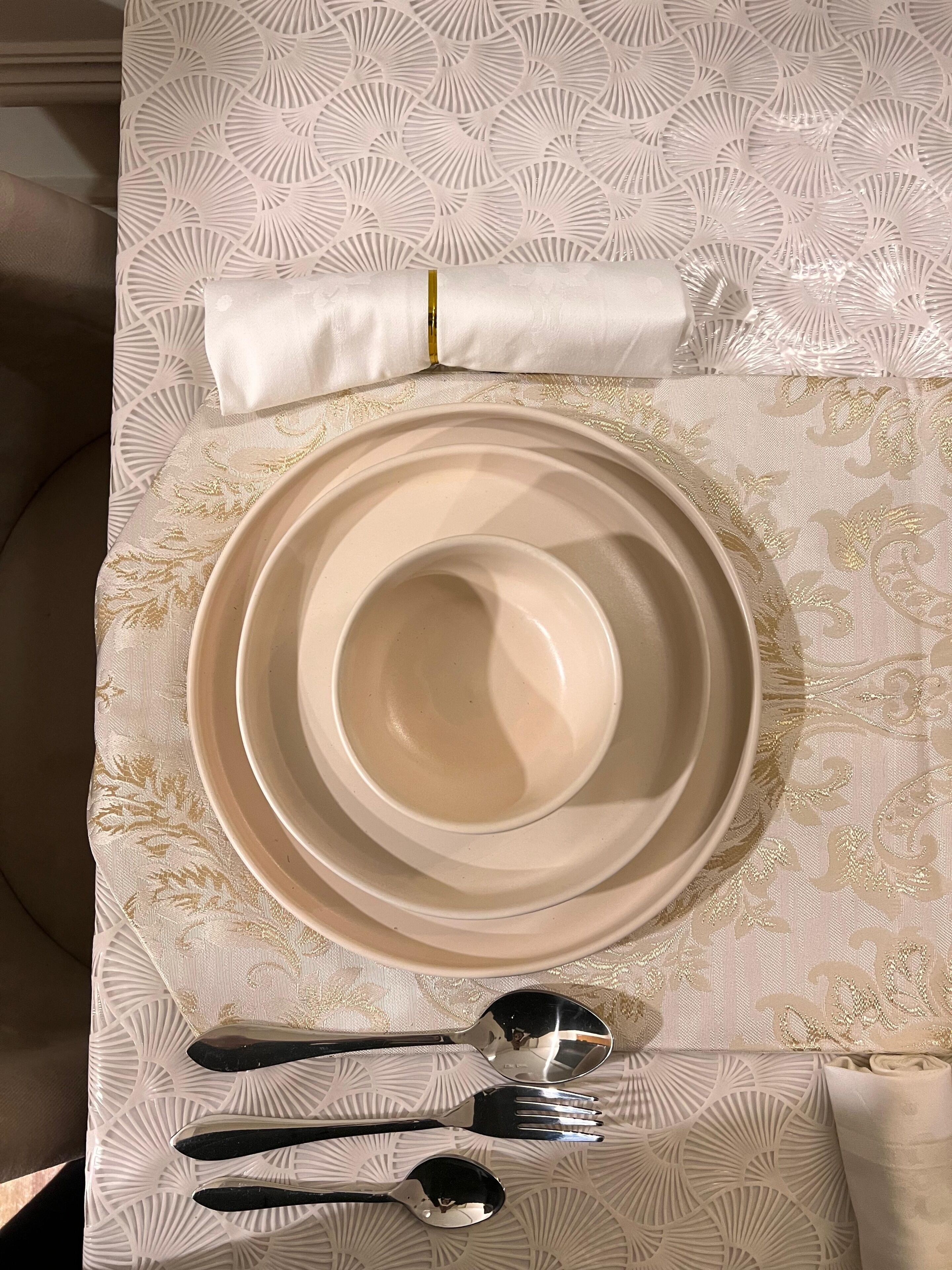A dining table set with plates, cutlery, and a napkin.
