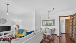 Un soggiorno moderno con divano, TV e zona pranzo.