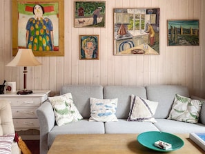 A living room with a grey sofa, a wooden coffee table, and a lamp.