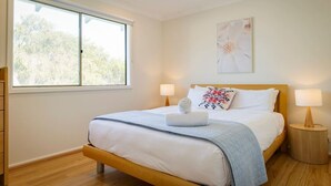 A bedroom with a bed, two bedside lamps, a window, and a ceiling fan. - Casa Lagoona - Coastal Retreat by the Beach (Quindalup)
