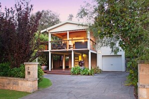 A two-story house with a balcony, a garage, and a well-maintained garden. - Casa Lagoona - Coastal Retreat by the Beach (Quindalup)