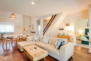 Ein modernes Wohnzimmer mit einem Ecksofa, einem Holztisch und einer Treppe zu einer anderen Ebene.