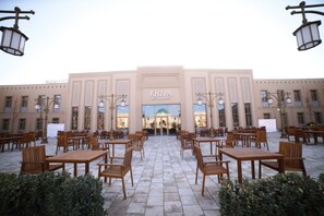 A restaurant with outdoor seating, a central entrance, and a decorative facade. - Arda Oasis (Khiva city)