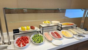 A buffet with various food items including fruits, vegetables, and meats. - Arda Oasis (Khiva)