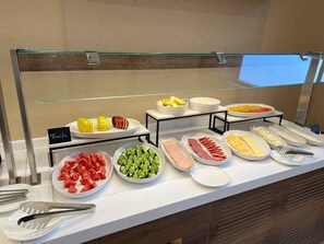 A buffet with various food items including fruits, vegetables, and meats. - Arda Oasis (Khiva)