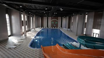 Una piscina techada, una piscina al aire libre de temporada, sombrillas