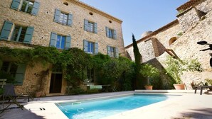 A stone building with a swimming pool, outdoor seating, and greenery. - Louna room (Saint-Victor-la-Coste)