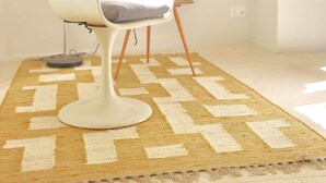 A modern room with a white chair, a patterned rug, a floor lamp, and a small shelf with items. - Louna room (Saint-Victor-la-Coste)
