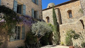 A stone building with arched windows and a courtyard. - Louna room (Saint-Victor-la-Coste)