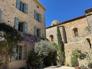 Un bâtiment en pierre doté de fenêtres en arc de cercle et d’une cour intérieure.