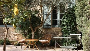 Une terrasse extérieure avec des meubles en osier, une table et des chaises.