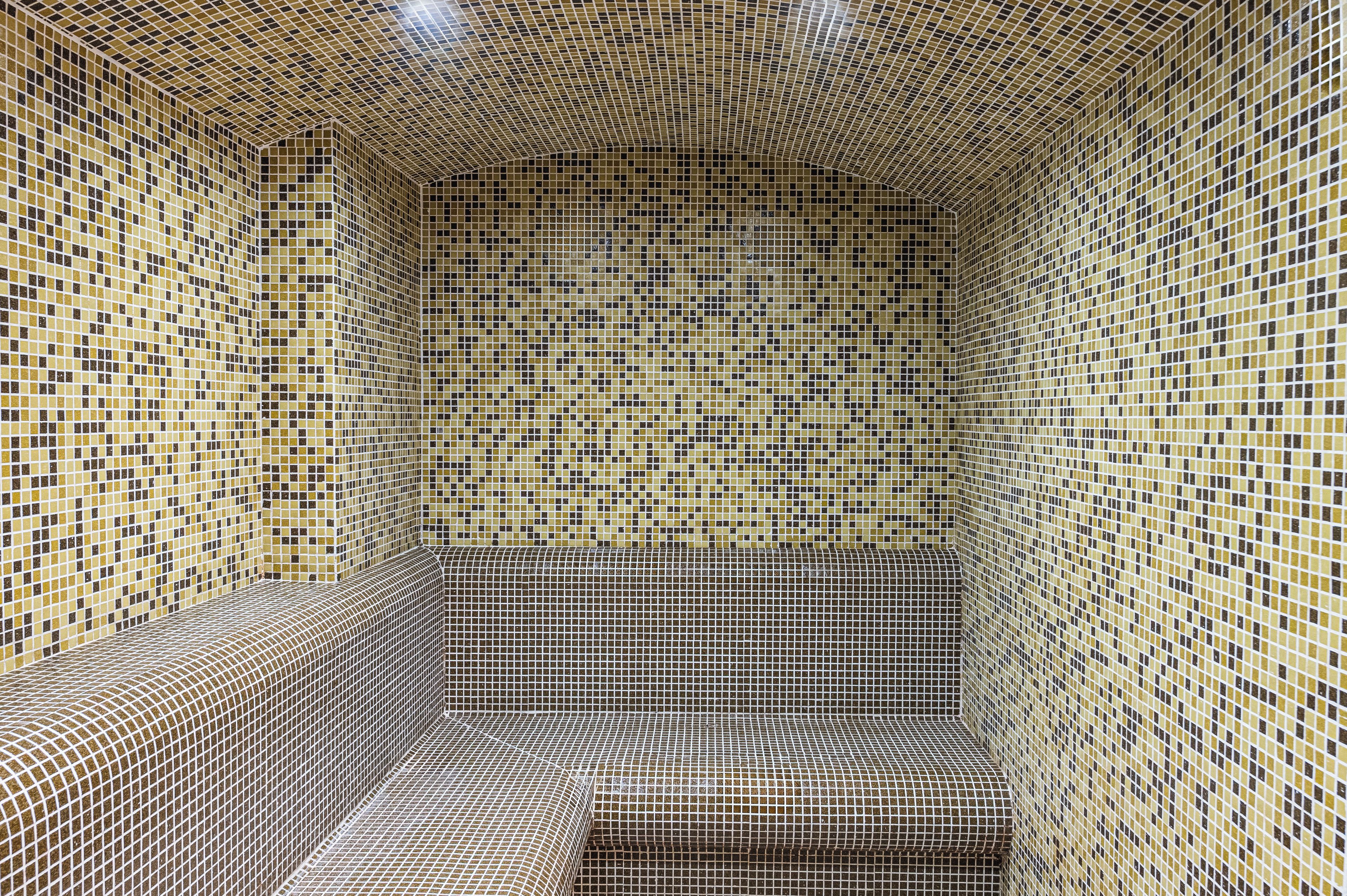 A room with a tiled floor and walls, featuring a geometric pattern.