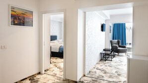 Una habitación de hotel con cama, una silla, una mesa y un cuadro en la pared.