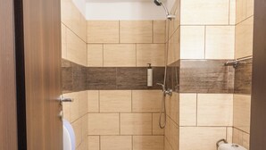 Un baño con inodoro, lavamanos y ducha.