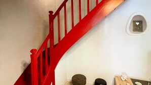A staircase with a red handrail leading to a landing.