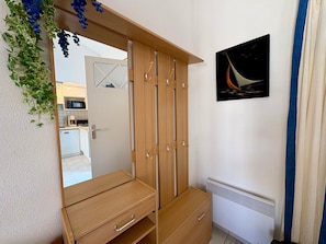 Ein Zimmer mit einem Holzschrank, einem Spiegel, einer Heizung und einem gerahmten Bild an der Wand.