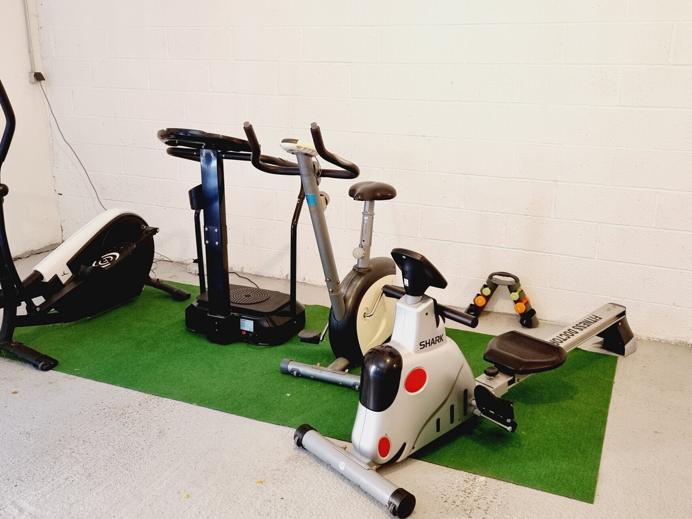 Une salle de sport équipée de vélos d’appartement, d’un tapis de course et d’un rameur.
