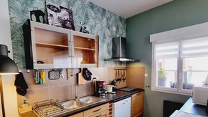 A kitchen with wooden cabinets, a dishwasher, a coffee maker, and a window with a view of the outside.