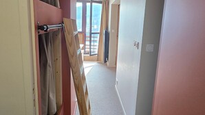 A hallway with a wooden ladder, a sliding door, and a view of a balcony with a wooden railing. - Apartment at the foot of the slopes - 6 guests (Besse-et-Saint-Anastaise-Super Besse)