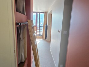 A hallway with a wooden ladder, a sliding door, and a view of a balcony with a wooden railing. - Apartment at the foot of the slopes - 6 guests (Besse-et-Saint-Anastaise-Super Besse)
