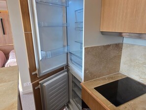 Eine Küche mit integriertem Kühlschrank, einer Arbeitsplatte und Holzschränken.