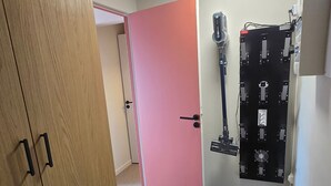 A room with a pink door, a wooden wardrobe, and a black wall-mounted device. - Apartment at the foot of the slopes - 6 guests (Besse-et-Saint-Anastaise-Super Besse)