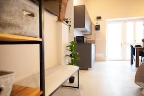 A modern kitchen with a built-in stove, a dining area with a table and chairs, and a bench with a potted plant.